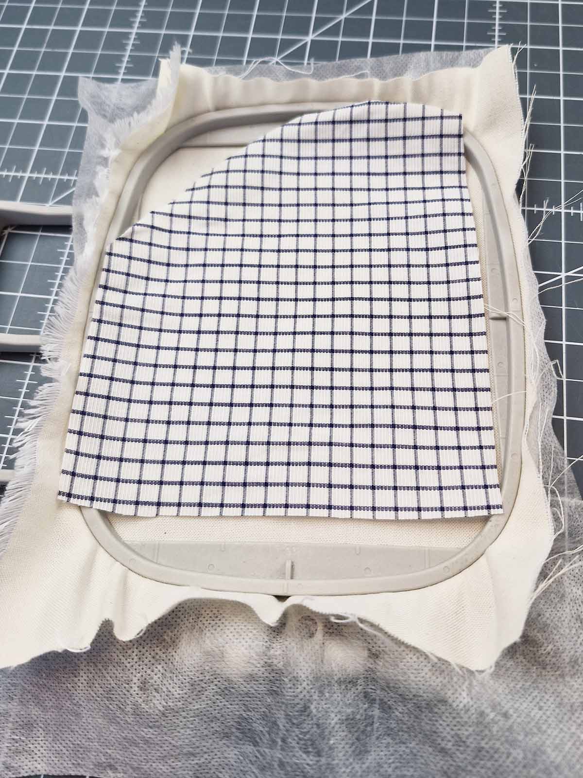 Appliqué fabric placed over the stitched heart outline in the embroidery hoop