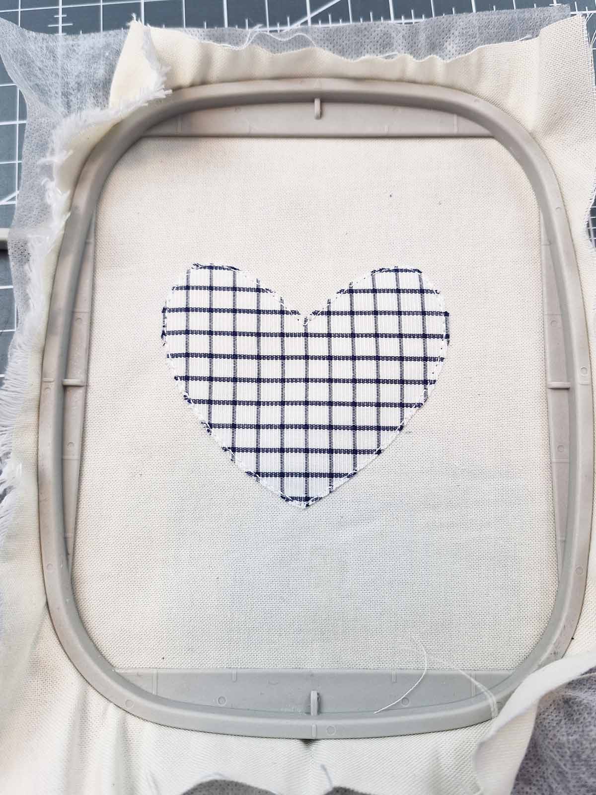 Appliqué fabric neatly trimmed while remaining hooped