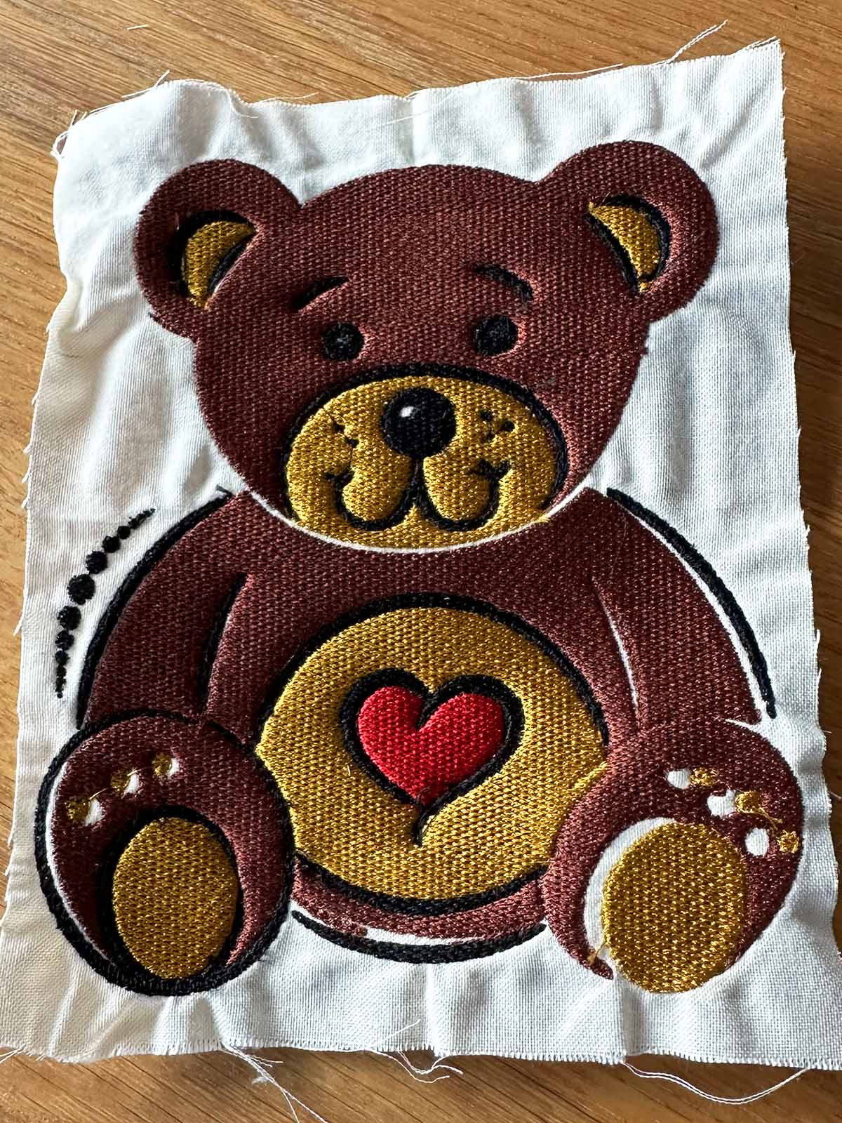 Close-up of embroidery with visible fabric distortion and gaps caused by excessive stitching