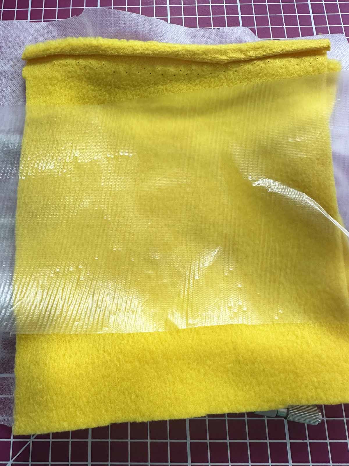 Padding layer placed on stitched wing area with water-soluble topping on top for clean embroidery stitches