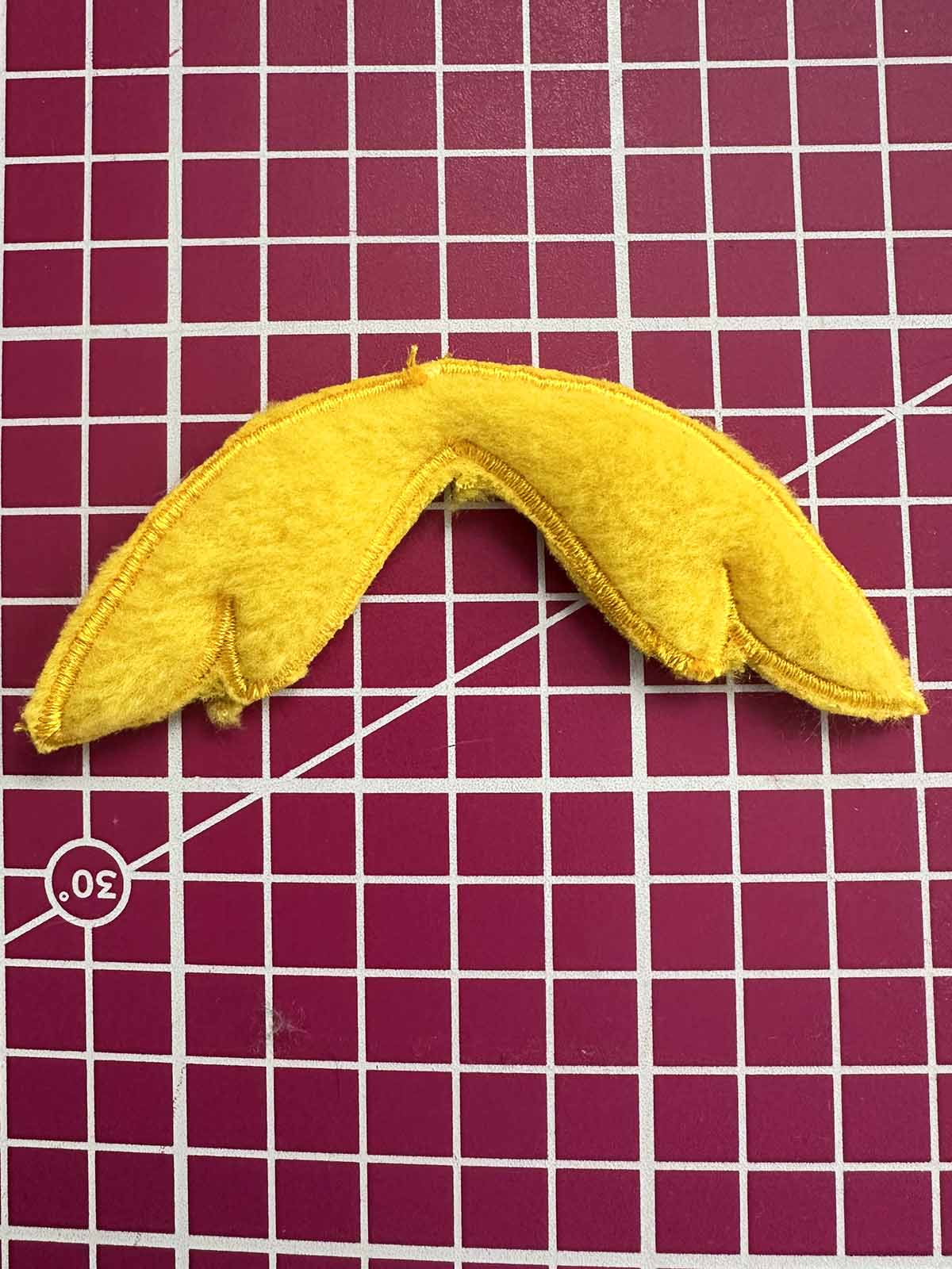 Finished embroidered duck wings cut out neatly from yellow plush fabric