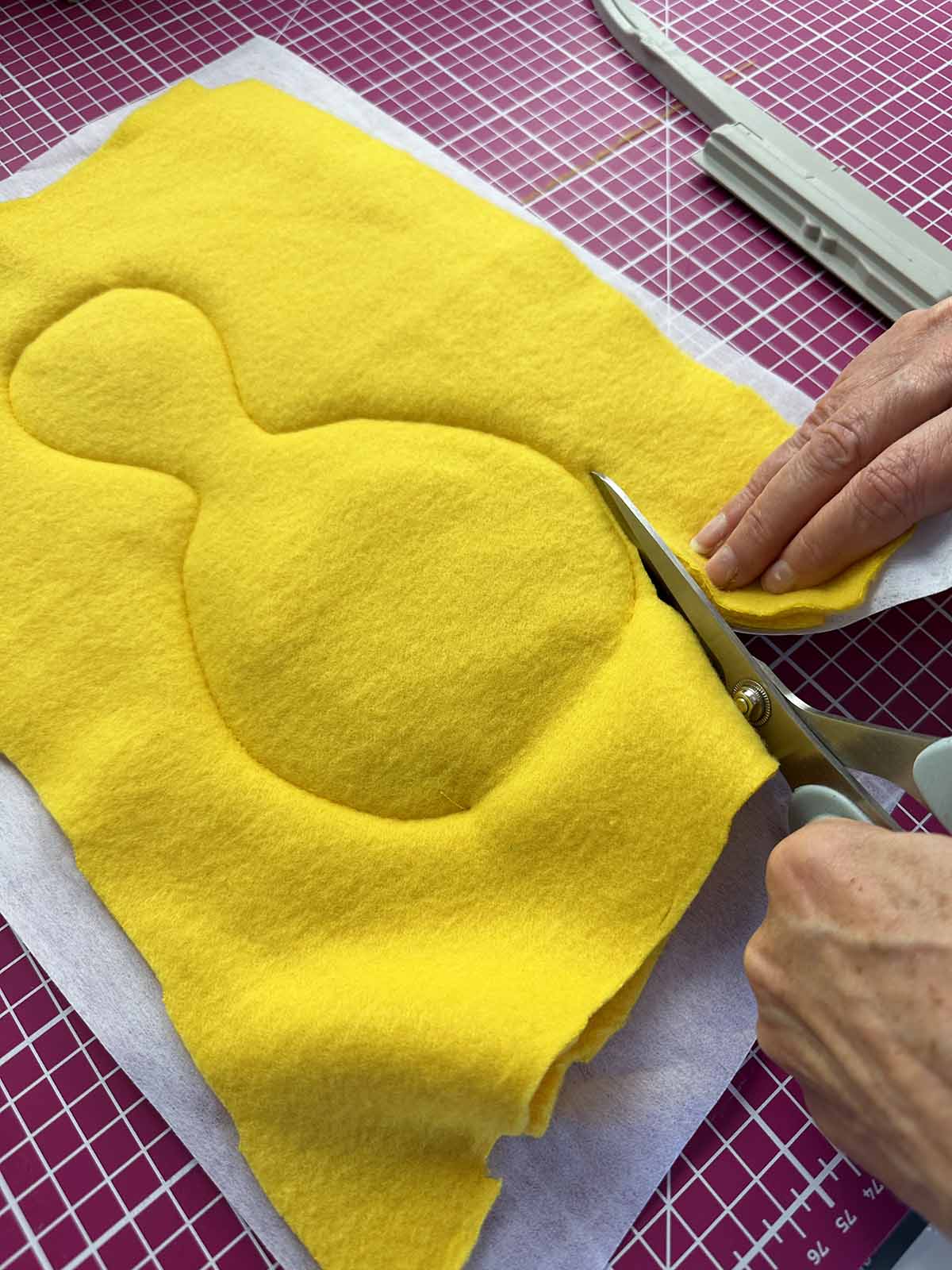 Duck body cut out along seam line using zigzag scissors after embroidery