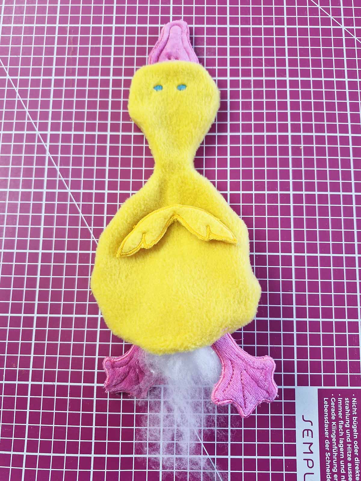 Plush duck turned right side out through opening with topping still slightly visible