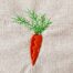 Carrot embroidery design with soft color transition and green leaves stitched on fabric