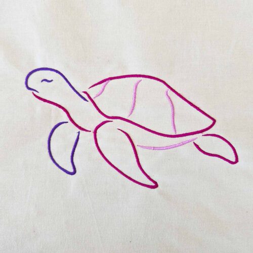 Turtle satin line art embroidery design stitched on cotton in purple, deep pink, and light pink thread.